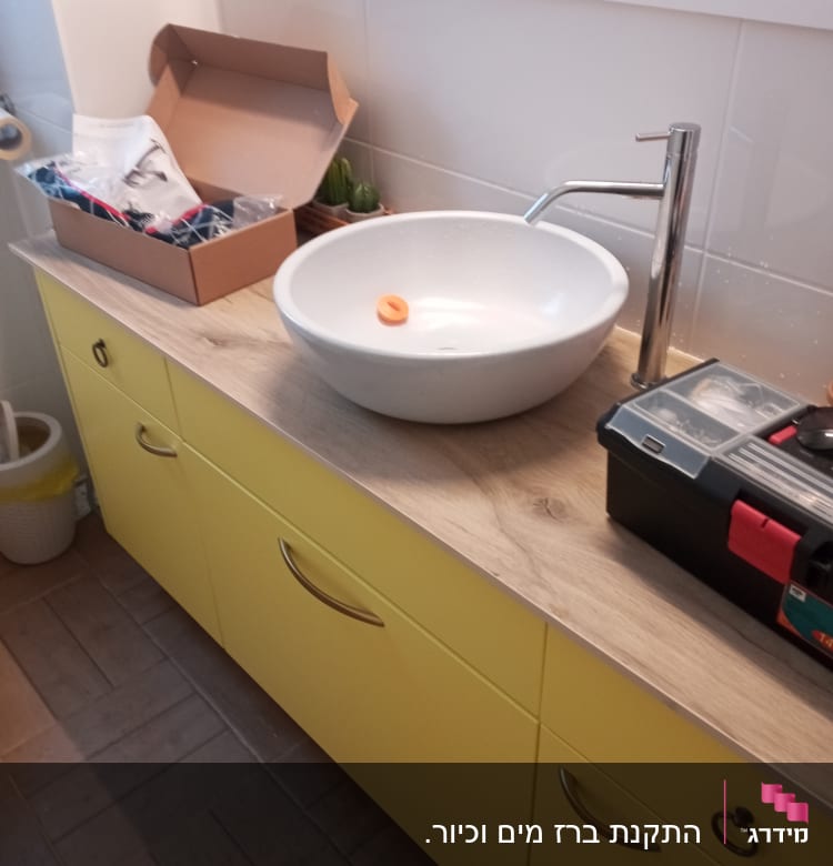 כיור עגול עם ברז וכלי עבודה לידו